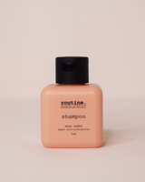 Pink square shampoo bottle labeled 'routine.' on a beige background